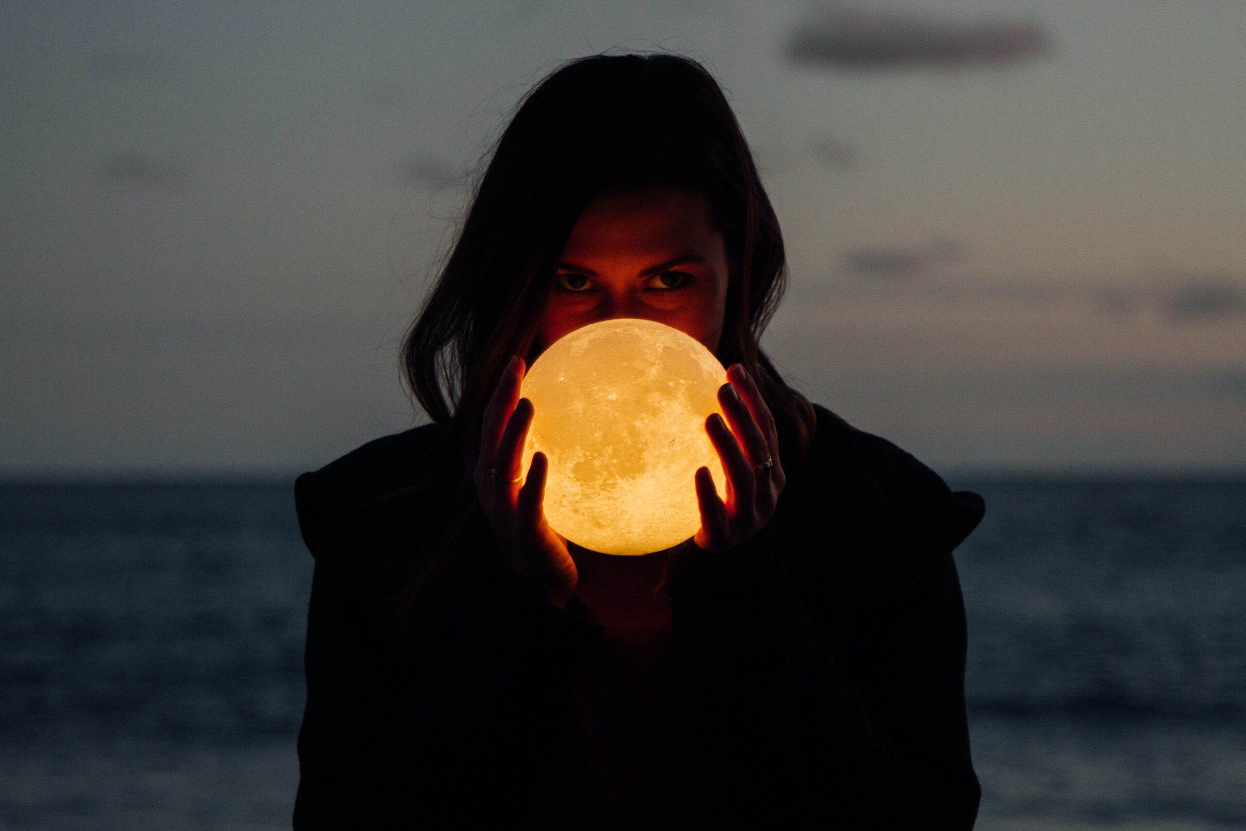 Image of a person holding a glowing full moon 