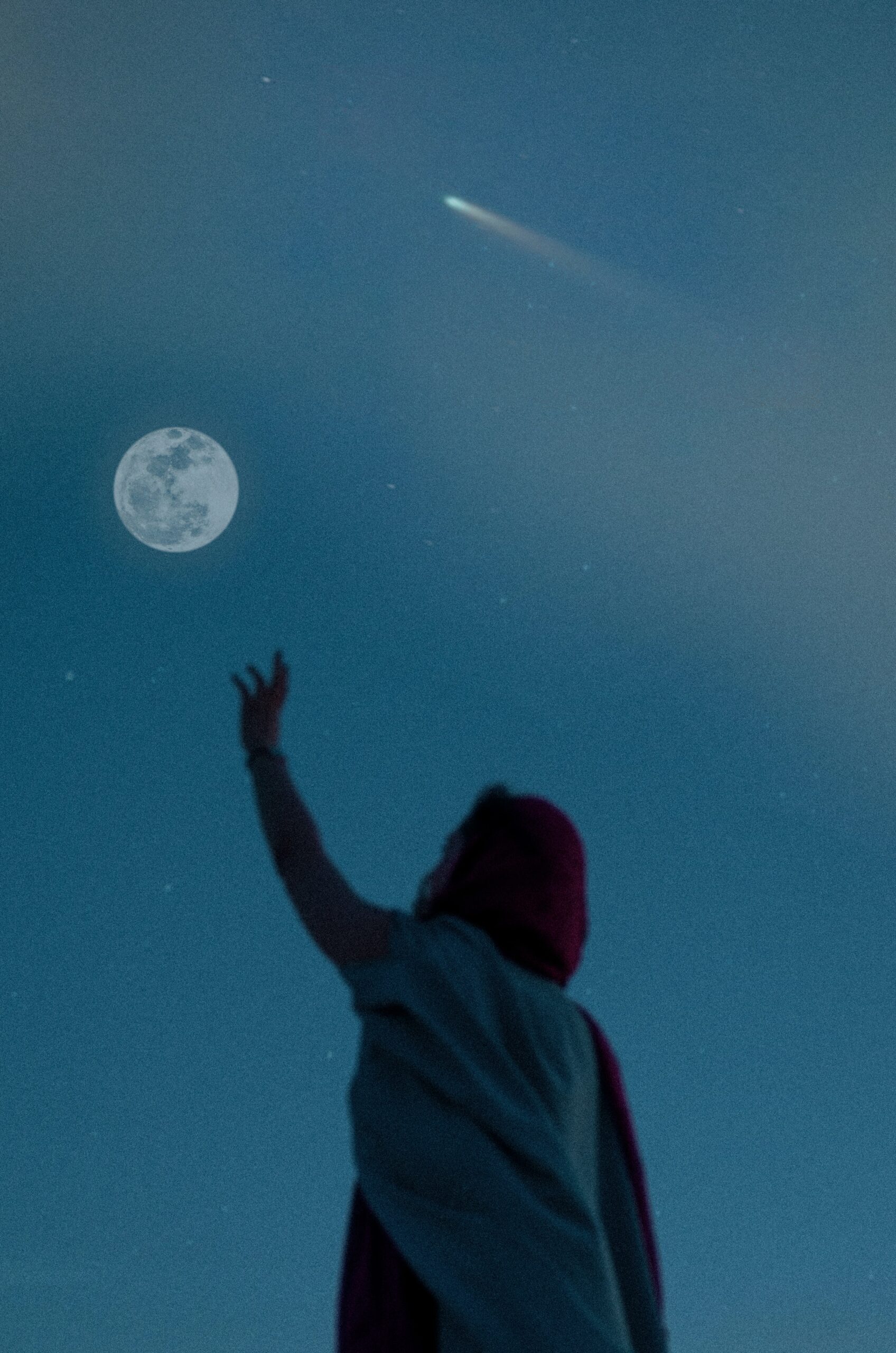 Photo of a person reaching for the full moon in the sky